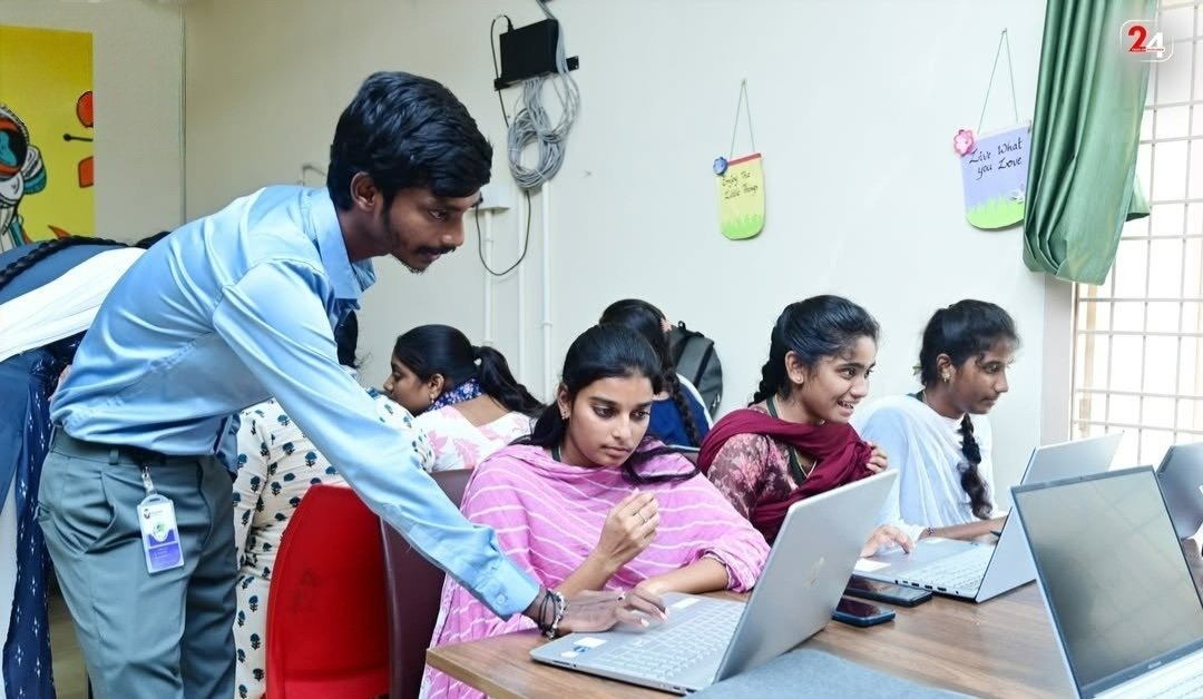Students learning together with a mentor at their laptops
